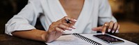 Woman writing down on her notebook