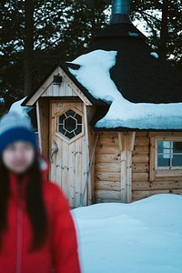 Woman standing in front of a log cabin