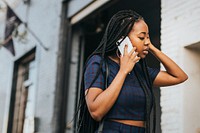 Black woman talking on the phone while walking on the streets
