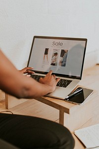 Black woman using a laptop on a wooden table