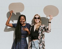 Cheerful women showing blank speech bubbles