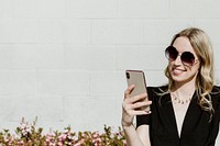 Cheerful woman with a sunglasses using her phone