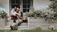 Cute black couple reading a book together in a garden