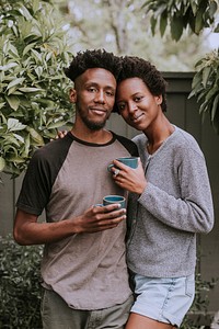 Black couple with coffee in the garden