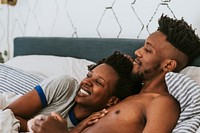 Cheerful black couple in bed