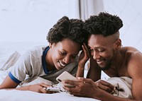 Happy black couple playing on a smartphone together