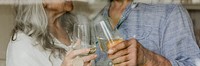 Elderly couple clinking their white wine glass