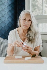 Senior woman rolling a joint