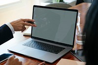 Businessman working on a laptop in a board meeting