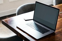 Laptop on a wooden table in a meeting room