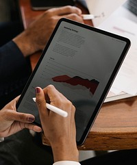 Businessperson taking note on a digital tablet