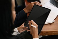 Business person using a wireless stylus with a digital tablet in a meeting