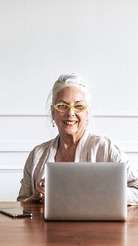 Cheerful senior CEO using a laptop