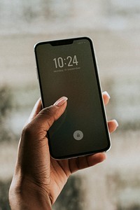 Hand holding smartphone by the window