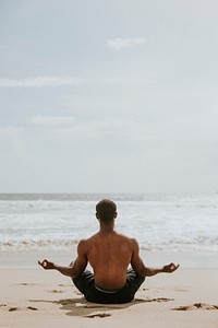 Black man meditating at the beach