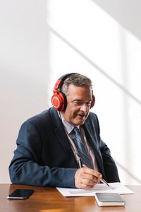 Businessman at his desk wearing red headphones