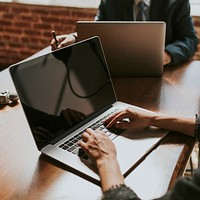 Businessman working on a laptop in a board meeting