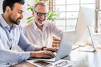 Cheerful web developers working on a laptop