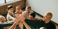 People joining hands in the air at a meeting