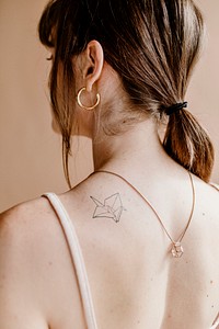Woman with a paper bird tattoo on her back