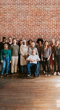 Group of diverse people standing in front of a brick wall