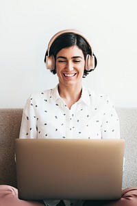 Happy woman with headphones on the couch