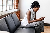 Woman sitting on a couch using smartphone