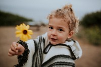 Blonde little girl holding a flower