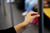 Hand touching a coronavirus contaminated train handrail