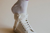 Model putting on white sneaker close up
