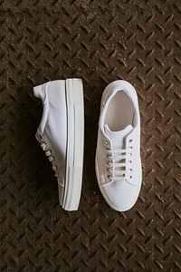 White canvas sneakers on metal texture