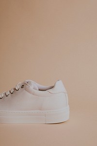 Woman's white canvas sneaker on beige