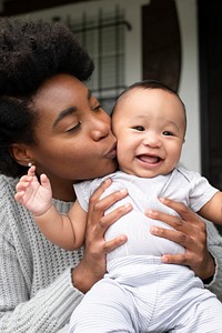 Cheerful African American mother kissing her son