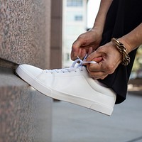 Canvas sneakers white model tying shoelaces apparel ad
