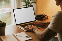 Tattooed man working on tablet screen mockup