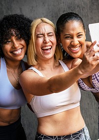 Cheerful sporty women taking a selfie at the gym