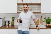 Happy man drinking coffee in the kitchen