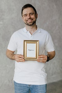Cheerful man holding a golden frame mockup