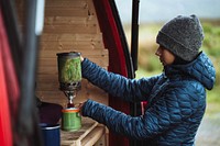 Woman using a portable camping stove to boil water