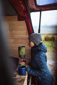 Woman using a portable camping stove to boil water