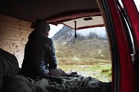 Woman sitting in her campervan looking at the mountains