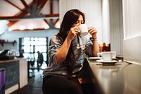Woman sitting in a cafe sipping coffee