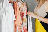 Woman in a yellow dress selecting cloth from a rack