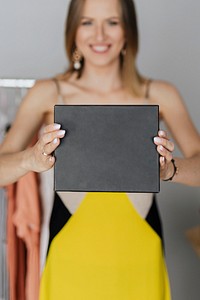 Smiling woman displaying a black minimal box