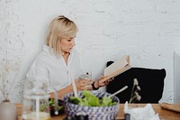 Pregnant woman reading a book while eating