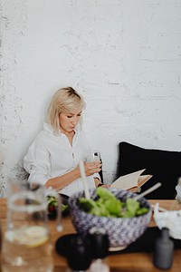 Pregnant woman reading a book while eating