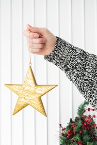 Woman holding a glittery gold star Christmas ornament
