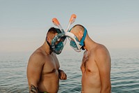 Men with full face snorkel mask standing against each other at the beach
