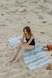 Woman using her phone at the beach