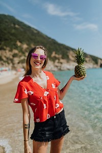 Girl holding a pineapple at the beach